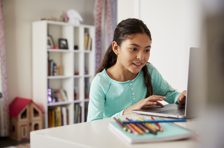 Young female student working on a laptop at home.